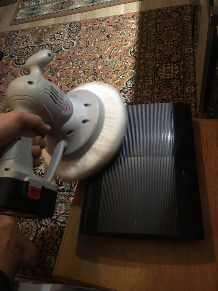 Polisaj işlemi pasta cila ile Playstation 3'ün çiziklerini temizlemek.